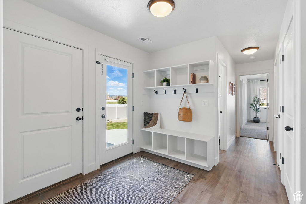 Mudroom with baseboards, plenty of natural light, wood finished floors, and visible vents