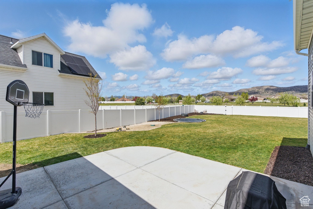 View of patio with a mountain view and a fenced backyard