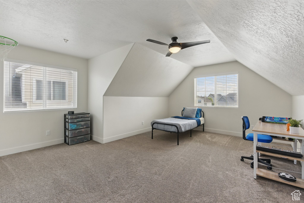 Bedroom with baseboards, carpet flooring, a textured ceiling, and lofted ceiling