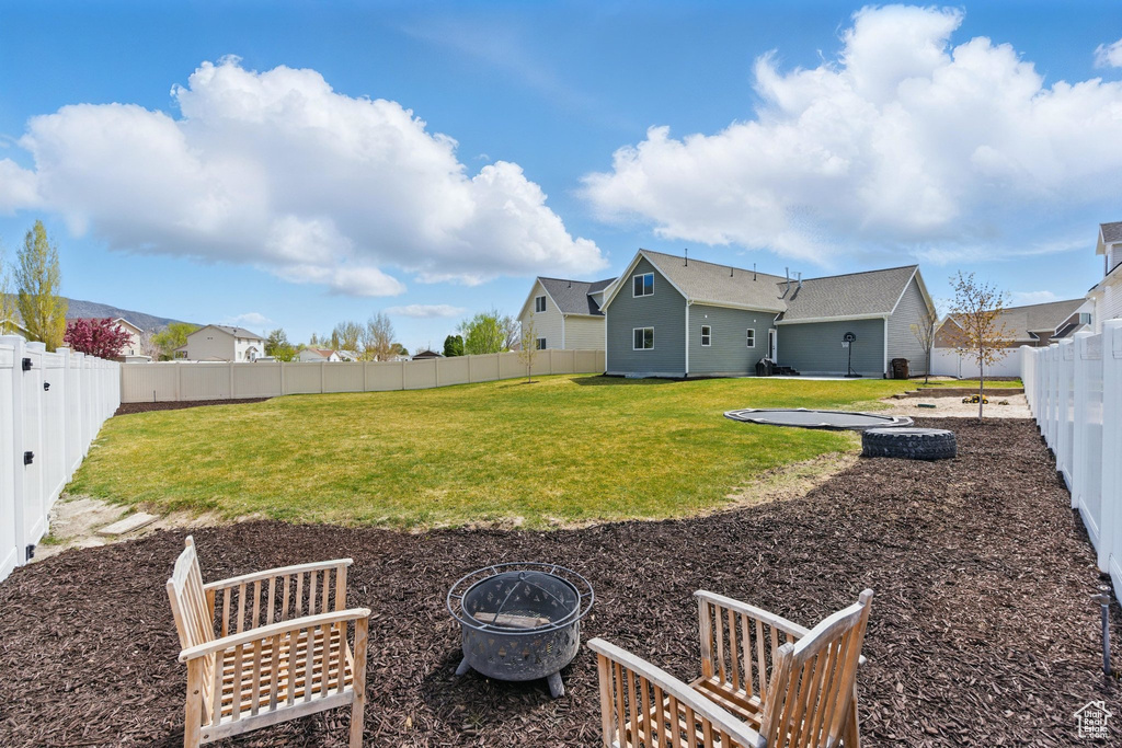 View of yard featuring a fenced backyard and a fire pit
