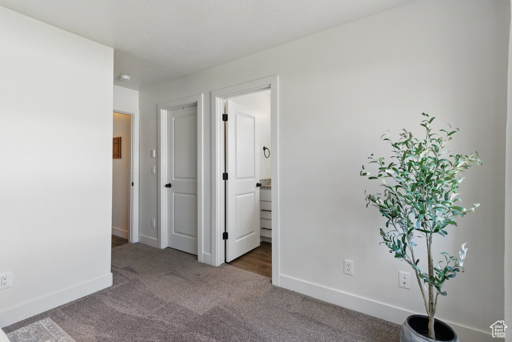 Unfurnished bedroom featuring carpet flooring, baseboards, and ensuite bathroom