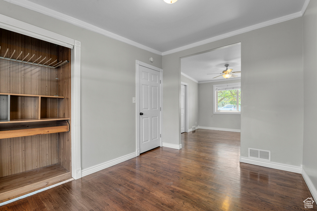 Unfurnished room featuring a ceiling fan, baseboards, visible vents, and wood finished floors