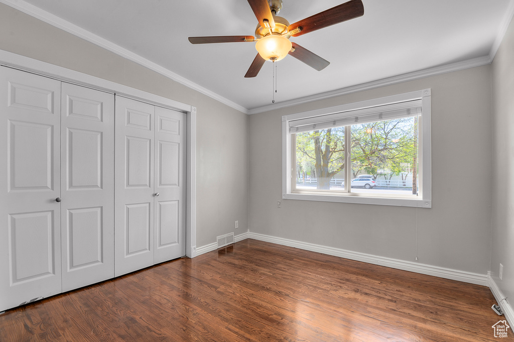 Unfurnished bedroom with baseboards, visible vents, dark wood finished floors, and a closet