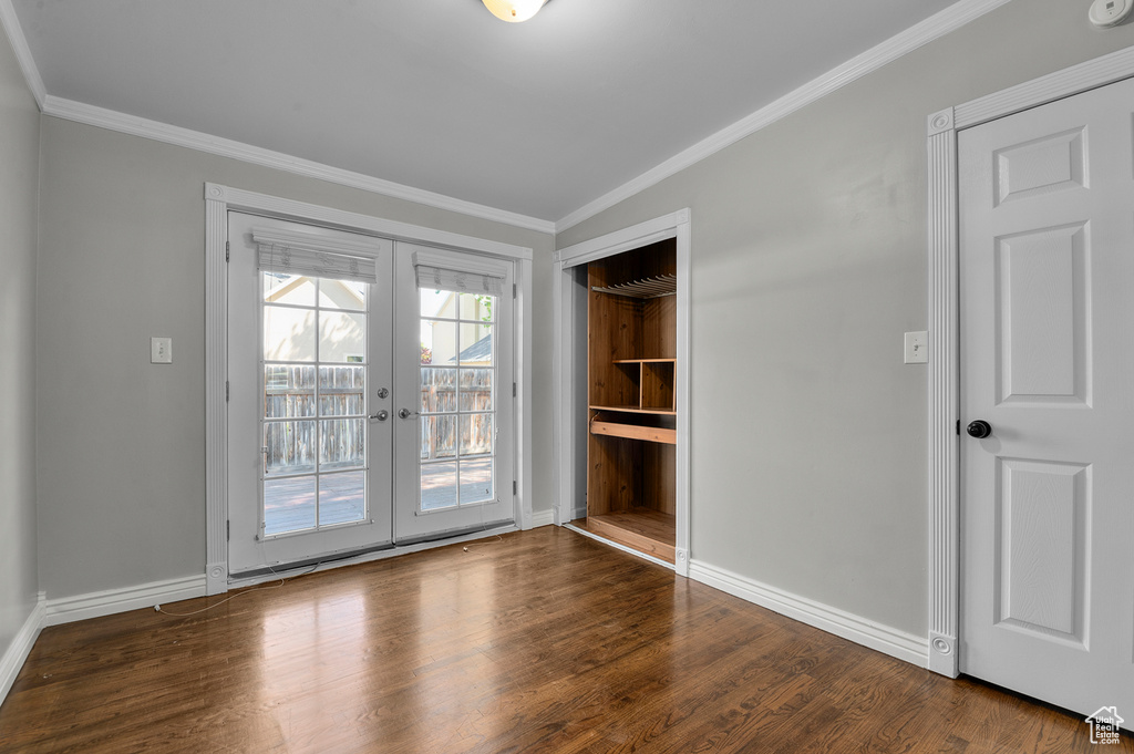 Spare room with french doors, baseboards, crown molding, and wood finished floors