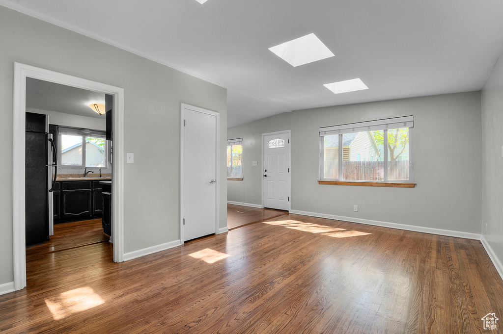Interior space with baseboards, a sink, and wood finished floors