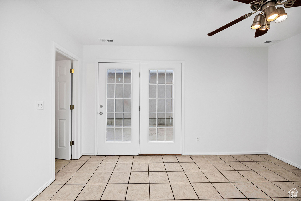 Unfurnished room featuring visible vents, baseboards, ceiling fan, and light tile patterned floors