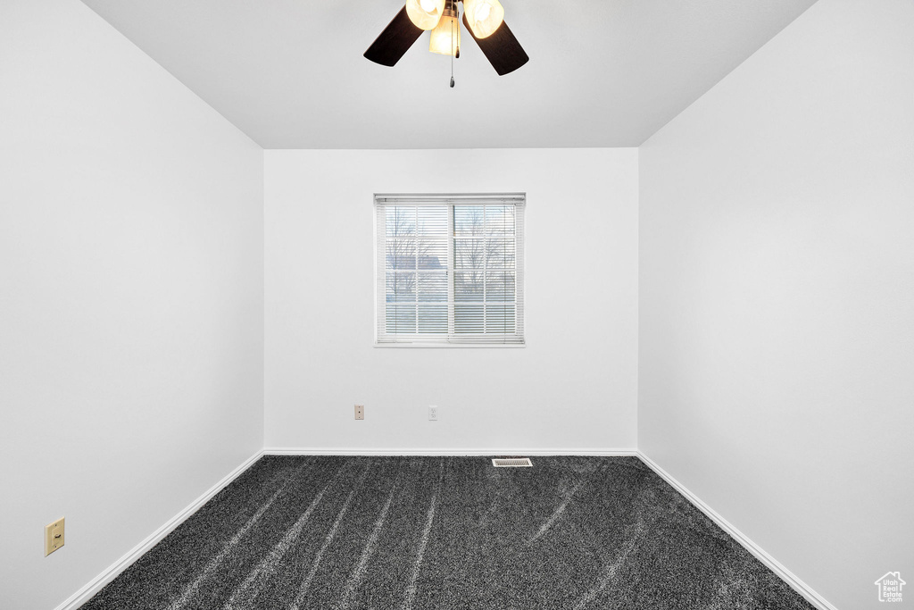 Unfurnished room featuring carpet floors, ceiling fan, baseboards, and visible vents