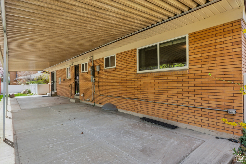 View of side of home with entry steps, fence, and brick siding
