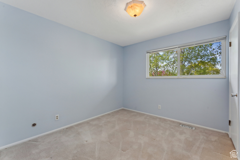 Unfurnished room with carpet floors, baseboards, and visible vents