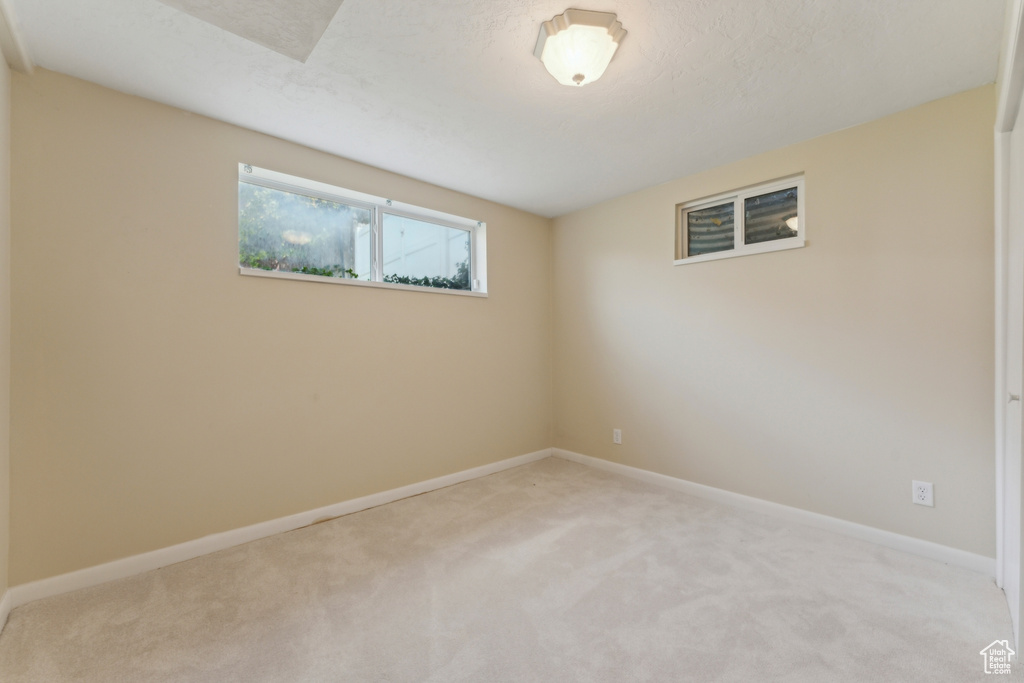 Spare room featuring baseboards and light carpet