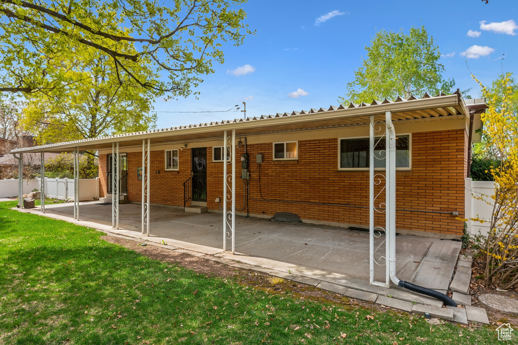 Rear view of house with a lawn, brick siding, a patio area, and entry steps