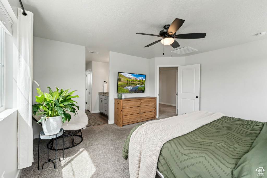 Bedroom featuring connected bathroom, carpet, a ceiling fan, baseboards, and visible vents