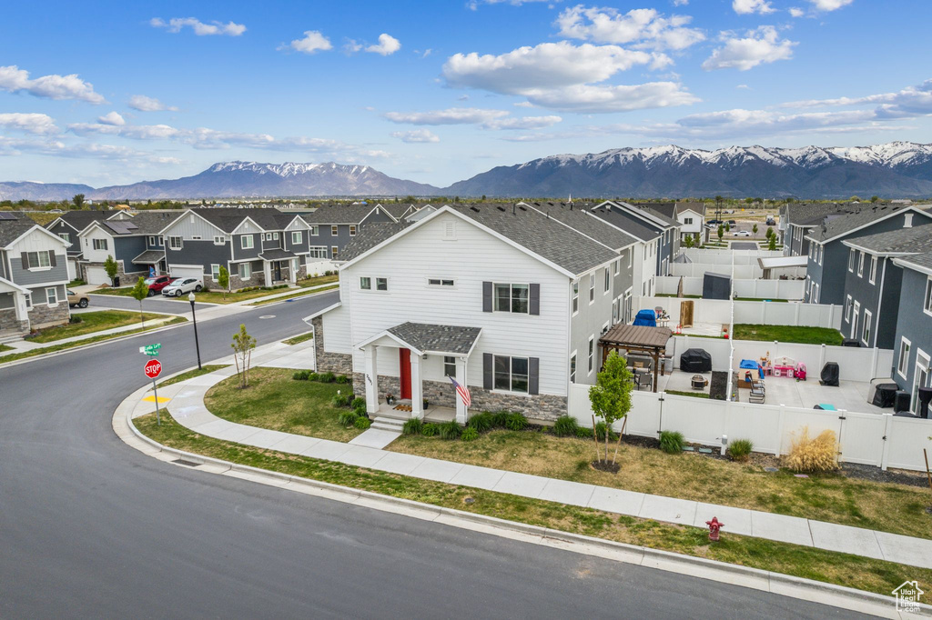 View of front of house featuring fence, a residential view, a mountain view, and stone siding