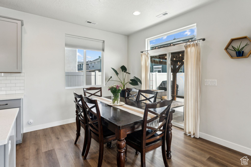 Dining area featuring visible vents, baseboards, and dark wood-style floors