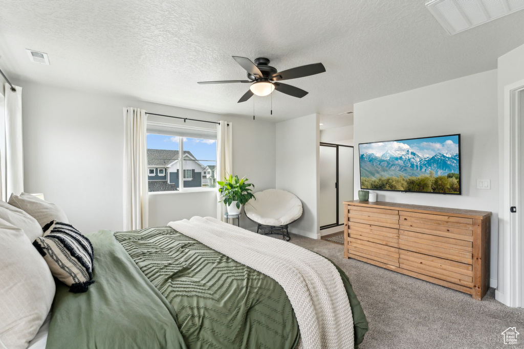 Bedroom with carpet, a ceiling fan, a textured ceiling, and visible vents