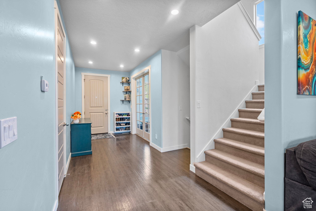 Foyer entrance featuring dark wood-style flooring, french doors, recessed lighting, baseboards, and stairway