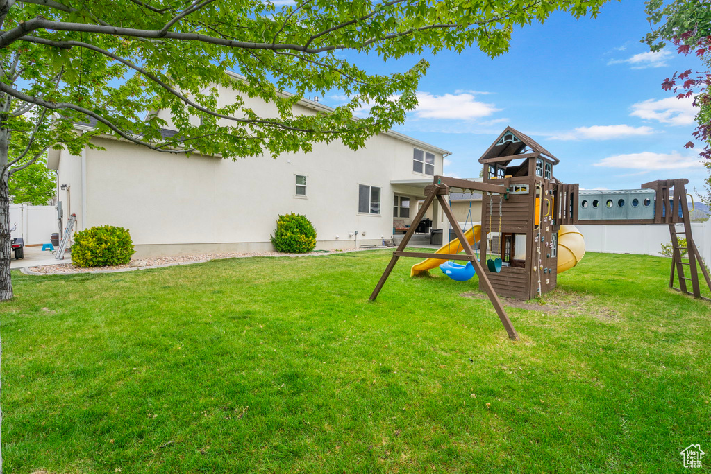 View of yard featuring a playground and fence