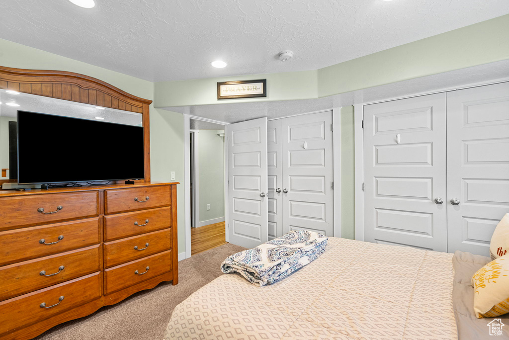 Bedroom featuring light carpet, recessed lighting, and a textured ceiling