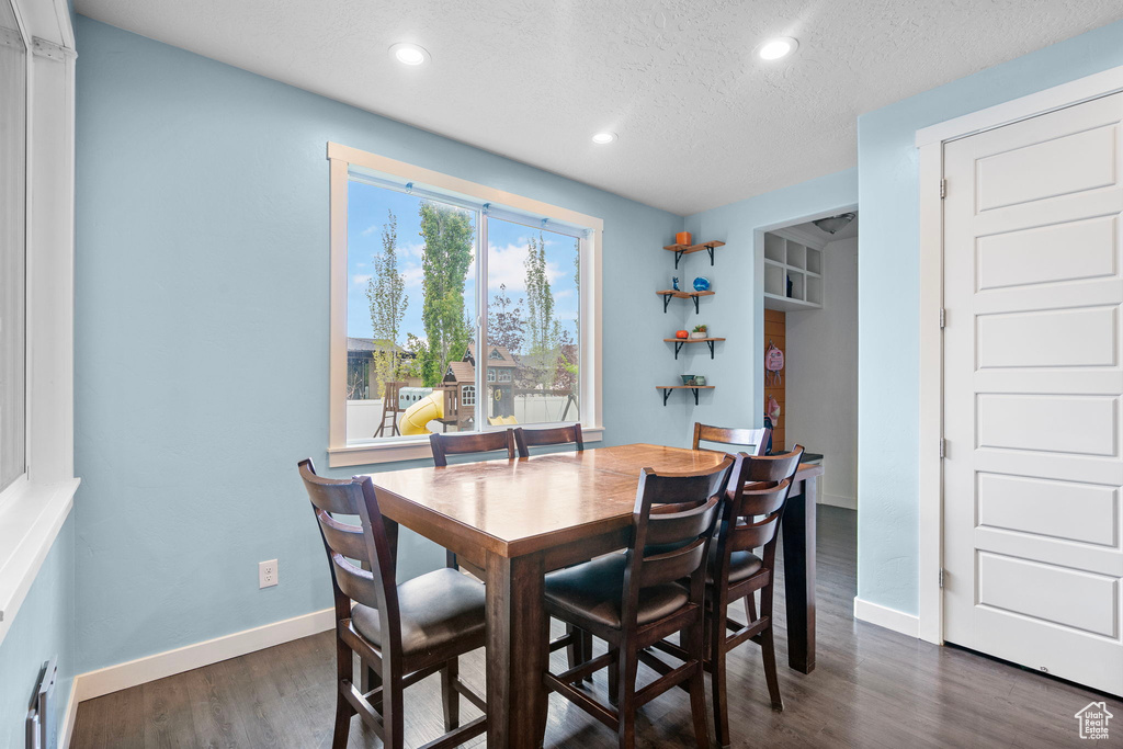 Dining area featuring recessed lighting, a textured ceiling, dark wood finished floors, and baseboards