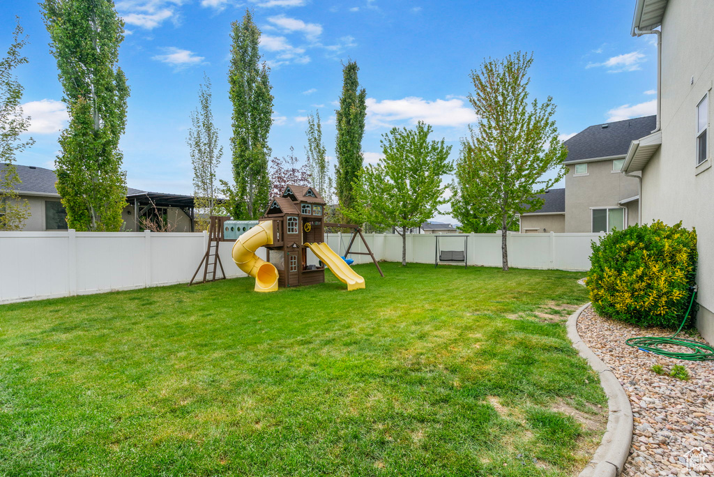 View of yard featuring a fenced backyard and a playground