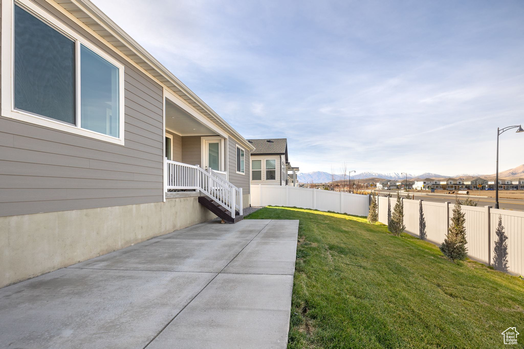 View of yard with a patio area, fence, and a mountain view