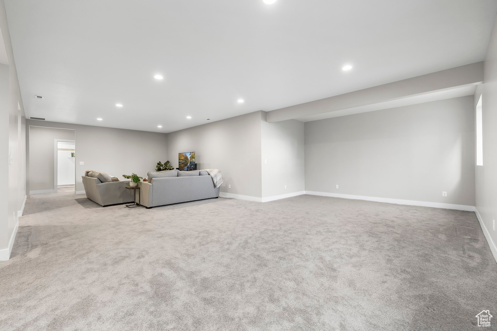 Unfurnished living room with carpet floors, recessed lighting, and baseboards