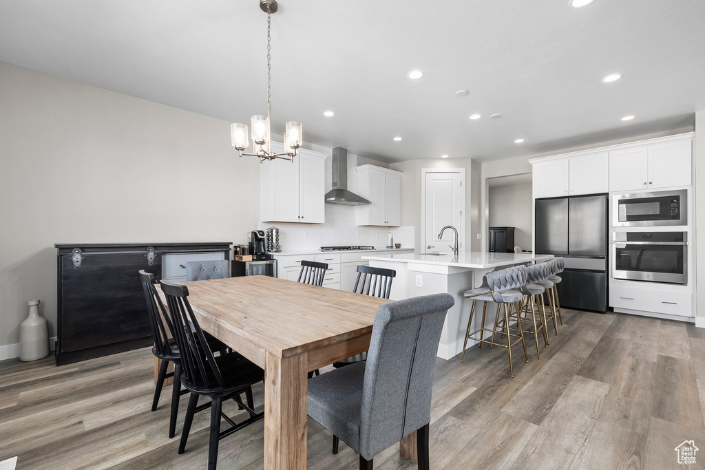Dining space featuring recessed lighting, light wood-style floors, and a notable chandelier