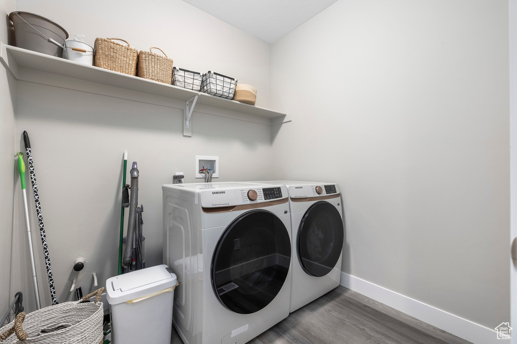 Laundry room with baseboards, laundry area, washer and clothes dryer, and wood finished floors