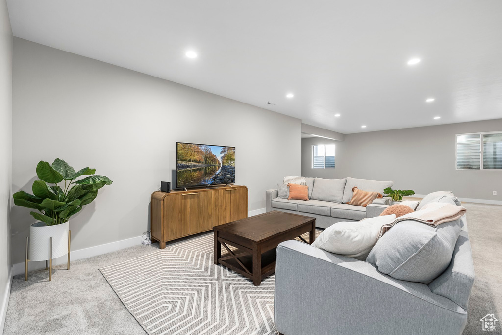 Living room featuring baseboards, recessed lighting, and light colored carpet