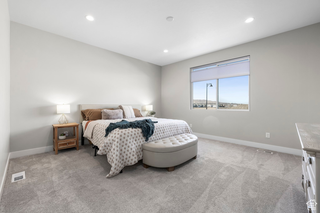 Carpeted bedroom with baseboards, recessed lighting, and visible vents