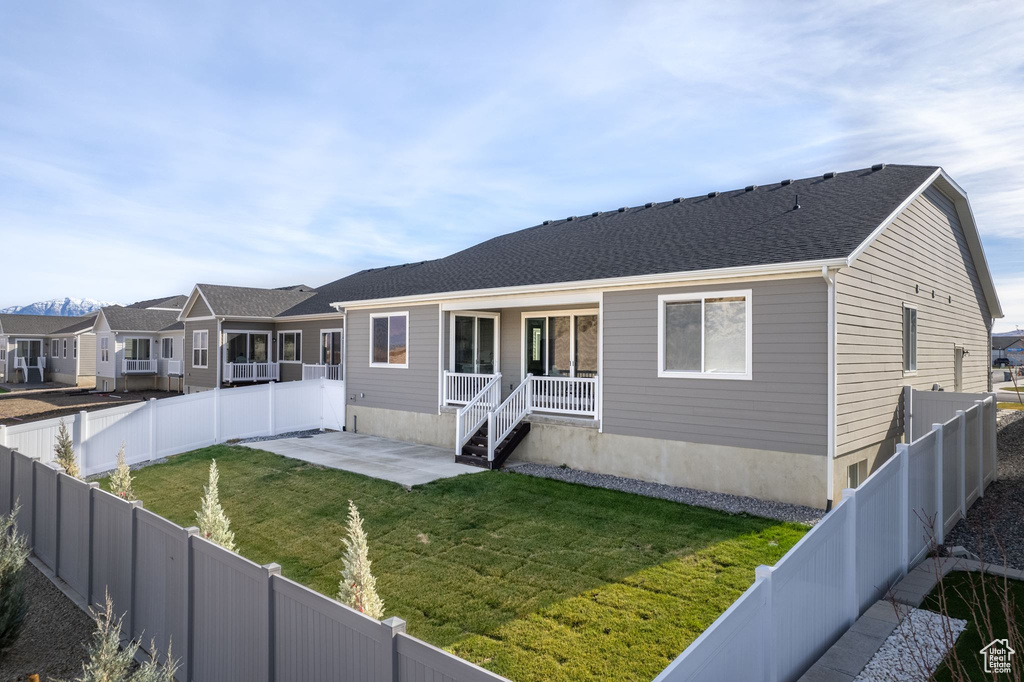View of front facade featuring a patio, a fenced backyard, and a front lawn