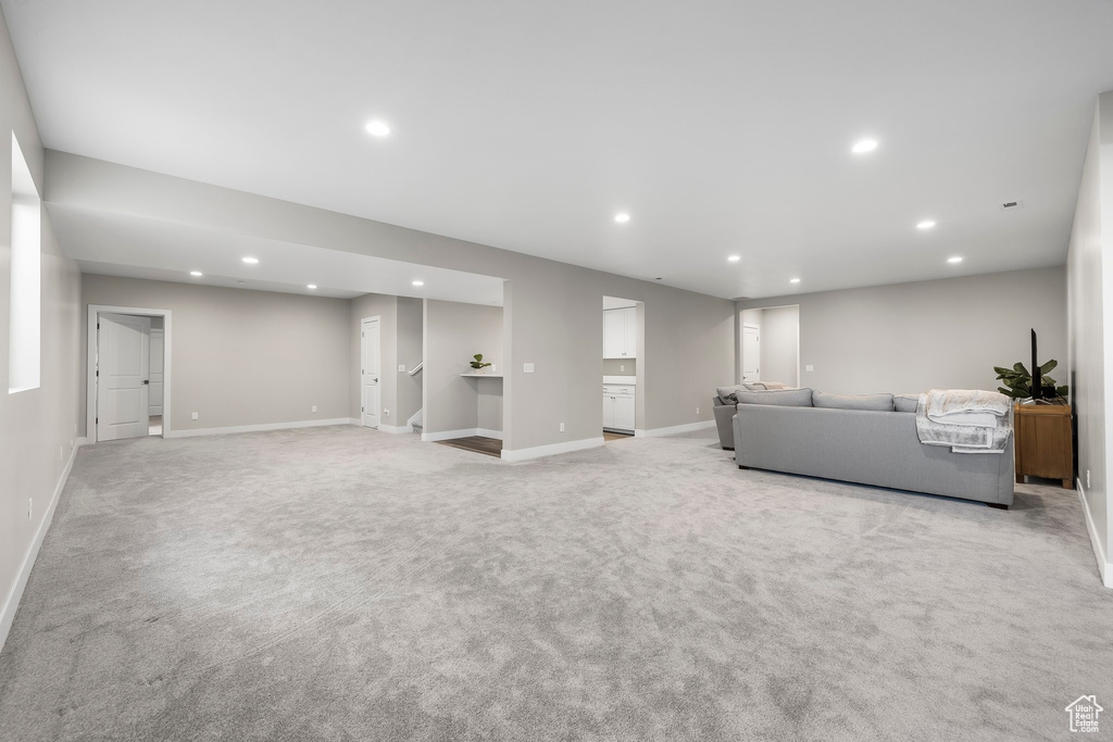 Living area with carpet floors, baseboards, and recessed lighting