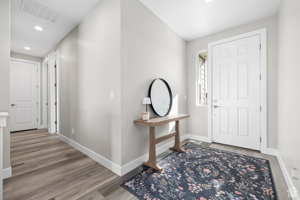 Foyer with recessed lighting, baseboards, visible vents, and wood finished floors