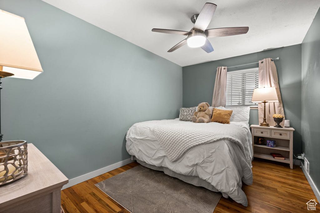Bedroom featuring baseboards, ceiling fan, vaulted ceiling, and wood finished floors