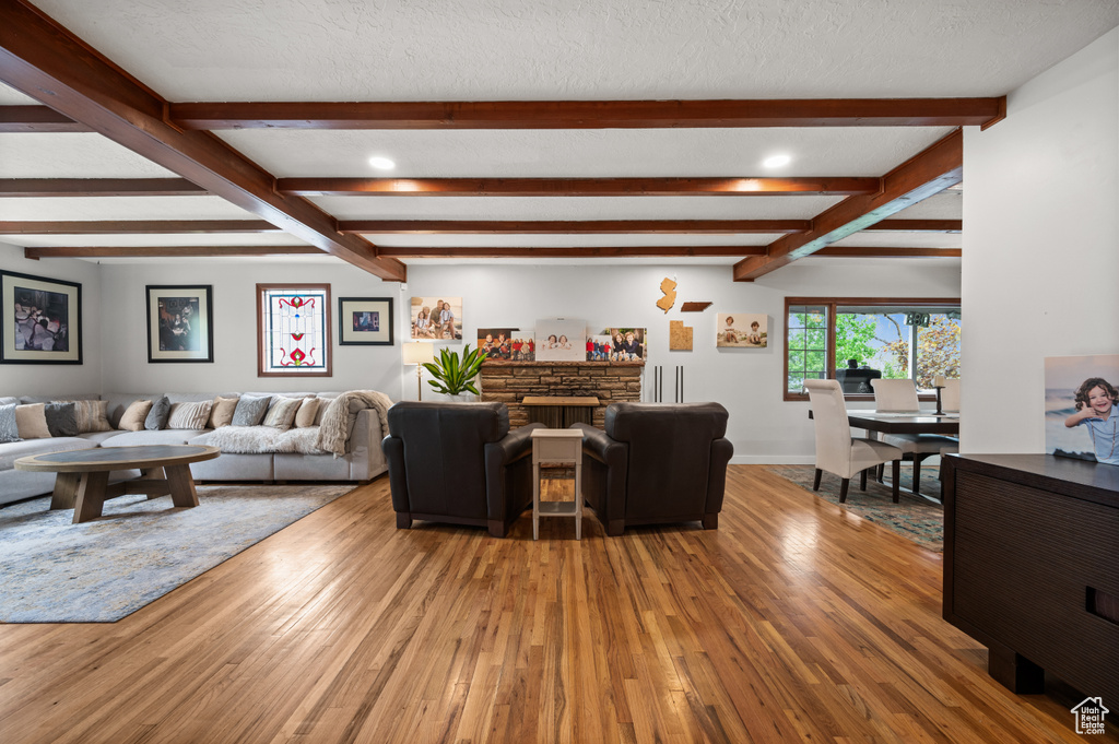 Living area with recessed lighting, beamed ceiling, and wood finished floors