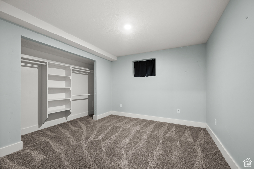 Unfurnished bedroom featuring carpet, baseboards, and a closet