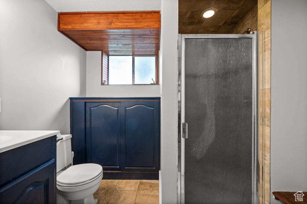 Bathroom featuring vanity, a stall shower, and toilet