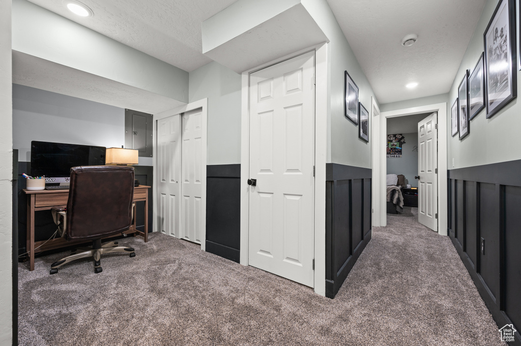 Carpeted office featuring recessed lighting and electric panel