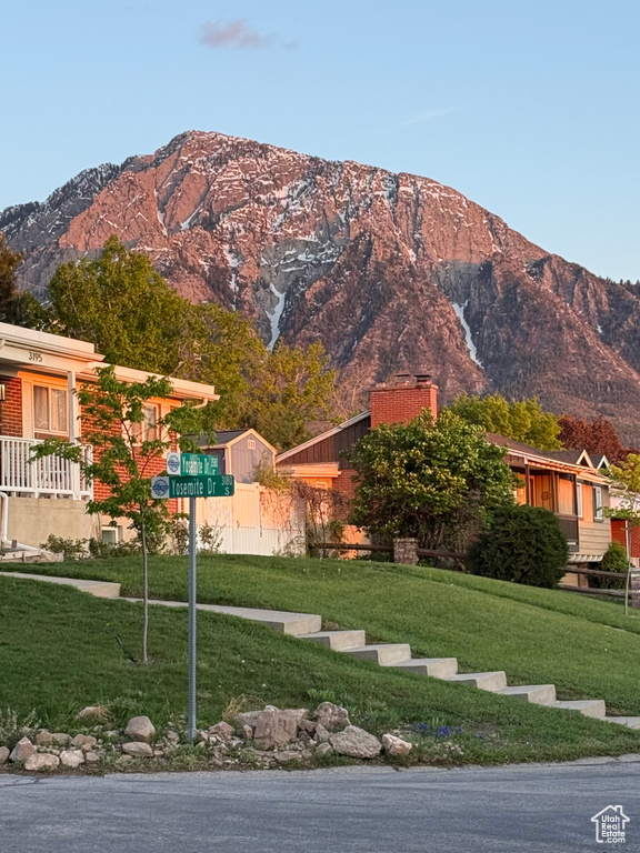 View of front of house featuring a front lawn, a mountain view, and a chimney