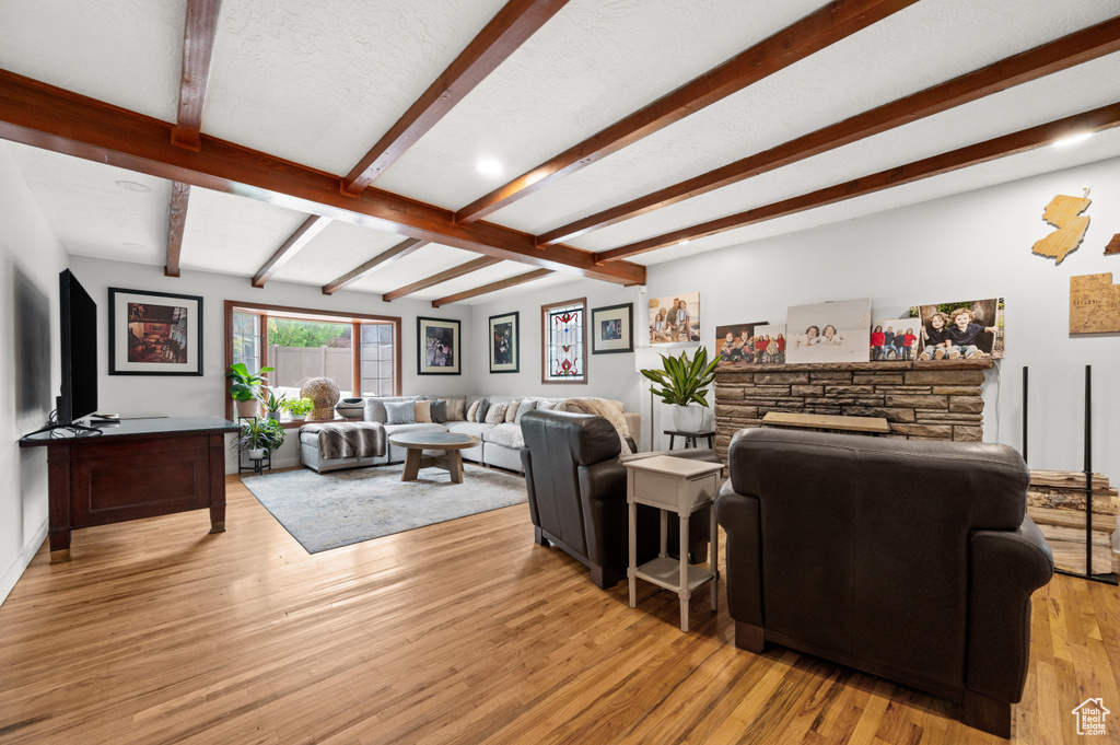 Living room featuring beam ceiling and light wood-style floors