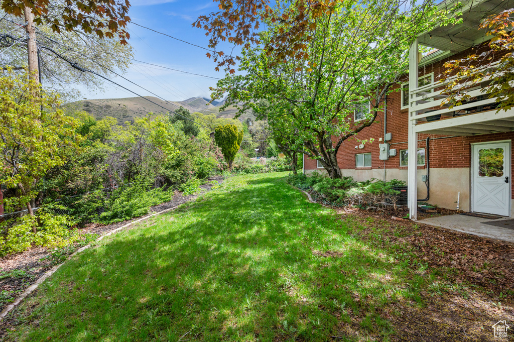 View of yard with a mountain view and a balcony