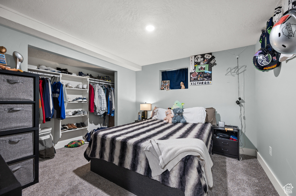 Bedroom featuring a closet, carpet flooring, and a textured ceiling
