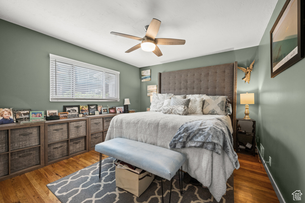 Bedroom with a ceiling fan, baseboards, and wood finished floors