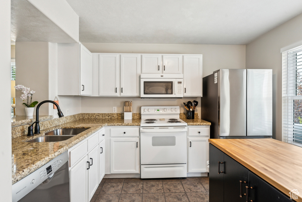 Kitchen featuring white cabinetry, appliances with stainless steel finishes, and a sink