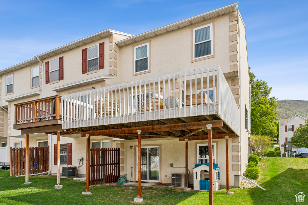 Rear view of property with central AC unit, stucco siding, and a wooden deck