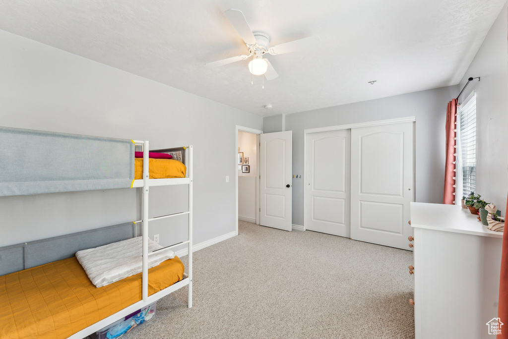Unfurnished bedroom featuring a closet, carpet flooring, baseboards, and ceiling fan