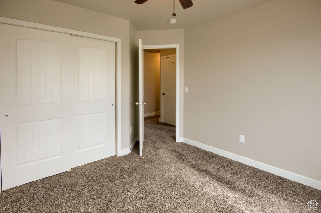Unfurnished bedroom with carpet floors, baseboards, a closet, and ceiling fan