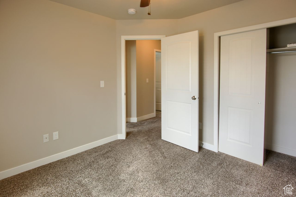 Unfurnished bedroom with a closet, carpet, and baseboards