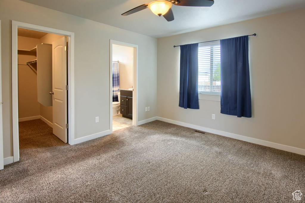 Unfurnished bedroom with visible vents, baseboards, a spacious closet, and carpet