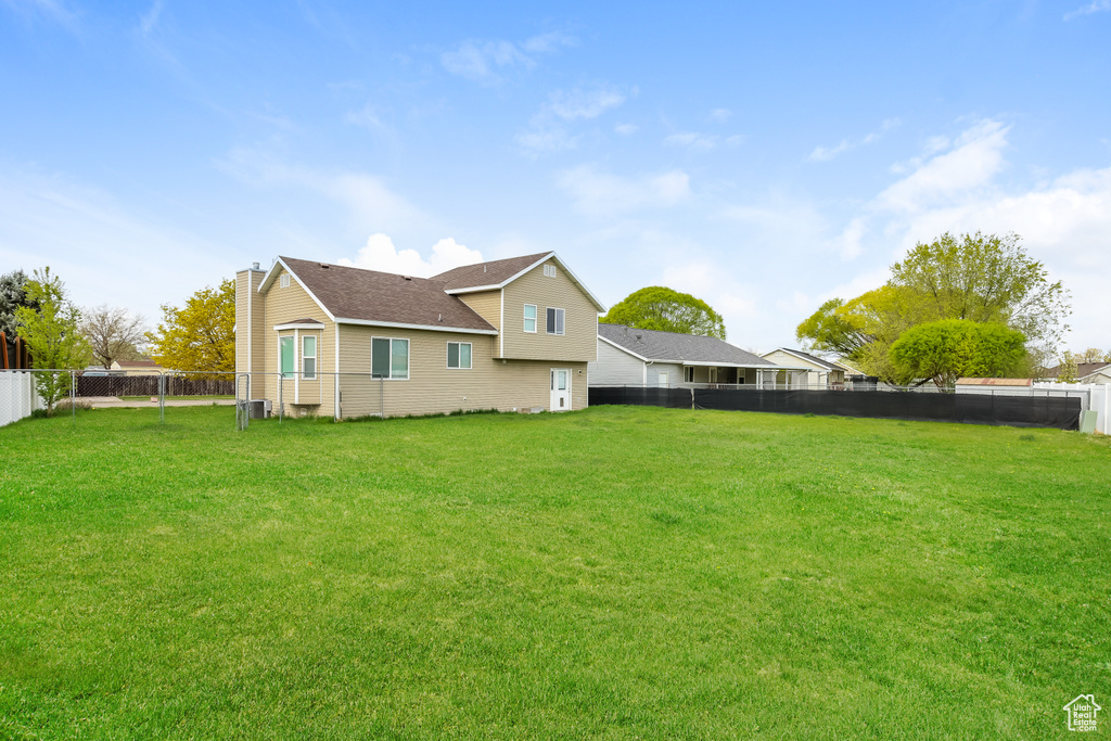 Exterior space featuring a lawn, a fenced backyard, and a chimney